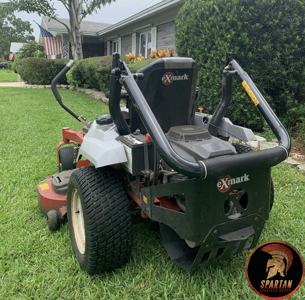 Zero turn riding mower on recently cut lawn.